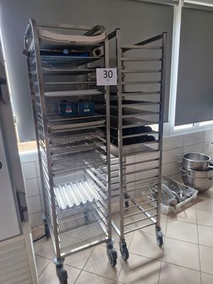 a metal rack with several trays of food on it