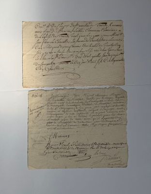 deux vieux papiers couverts d'écriture, posés sur une table