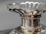 a silver vase that is sitting on top of a table