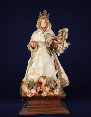 une figurine ancienne représentant une femme vêtue d'une robe blanche et tenant un oiseau