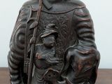 a statue of a man riding an elephant with a child on its back