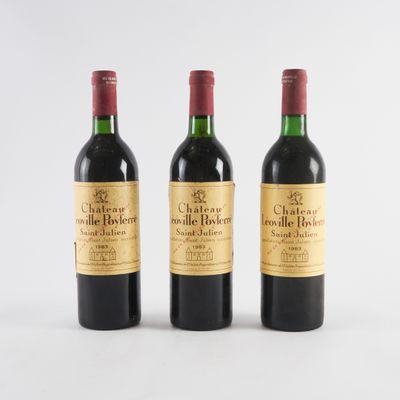 trois bouteilles de vin rouge posées l'une à côté de l'autre sur une surface blanche