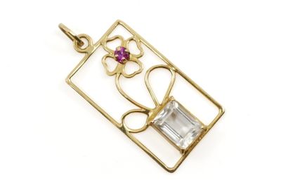 un gros plan d'un pendentif en or orné d'une pierre rose