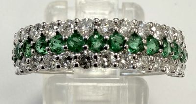 un gros plan d'une bague en diamant verte et blanche