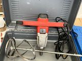 une perceuse rouge et noire dans une mallette à outils
