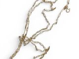 un gros plan d'un collier avec une chaîne posé sur une surface blanche
