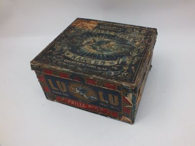 une vieille boîte en bois avec une étiquette posée sur une surface blanche