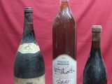 three bottles of wine are lined up on a red background