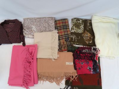 de nombreuses écharpes et foulards étalés sur un lit