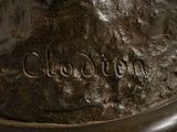 a bronze statue of a dog with a name written on it