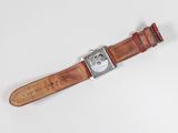 an image of a watch with a brown leather strap on a white surface