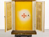 a yellow cabinet with a red cross painted on it