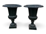 pair of black urns on pedestals on a white background