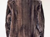 the back of a brown fur jacket on a mannequin stand