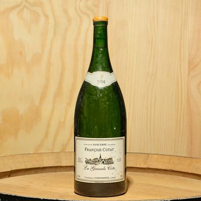 a bottle of wine sitting on top of a wooden barrel