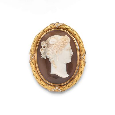 Une broche plaquée or représente le profil d'une femme.