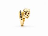 une image représentant une bague en or ornée d'une tête de lion aux yeux de saphir bleu