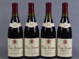 three bottles of red wine are lined up on a table