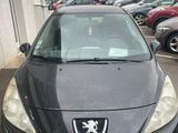 l'avant d'une voiture noire garée sur un parking à côté d'un immeuble