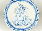 blue and white plate with a painting of a man and a woman on it