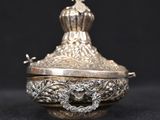 an antique silver plated box with a lid on a black background