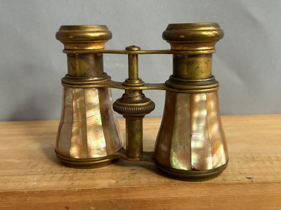 une paire de jumelles en laiton posée sur une table en bois