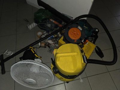 a yellow blower sitting on the floor next to a fan