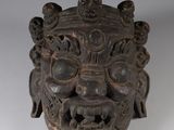 an image of a wooden mask on a white surface