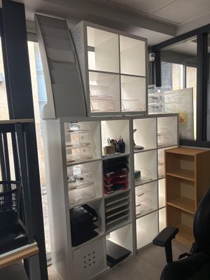 a desk with a chair and a book shelf in the corner