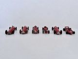 six petites voitures rouges alignées sur une surface blanche