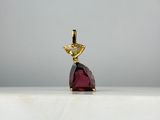 un gros plan d'un pendentif orné d'une pierre rouge sur un fond blanc
