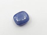 a blue sapphire stone on a white surface
