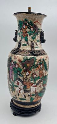 a vase with a painting on it sitting on a table