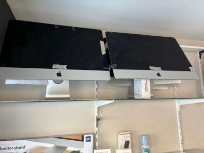 deux écrans d'ordinateur posés sur une étagère dans un magasin