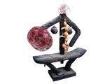 a sculpture of a man holding a ball on a bench