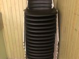 une pile de chaises noires dans un coin de la salle de bains