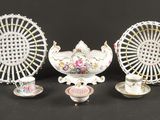 trois pièces de porcelaine différentes sur un fond noir, avec une grande roue