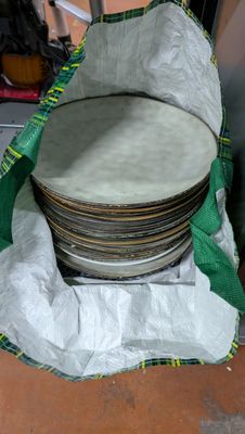 beaucoup d'assiettes dans un sac posé par terre