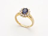 une image d'une bague en or avec un saphir et des diamants