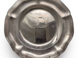 a silver plate with a handle on a white surface