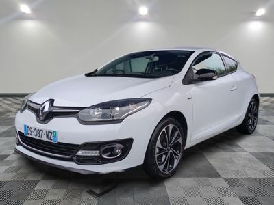 une voiture blanche est garée dans une pièce au sol à carreaux
