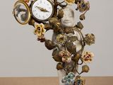 a statue of a woman holding a clock with flowers on it
