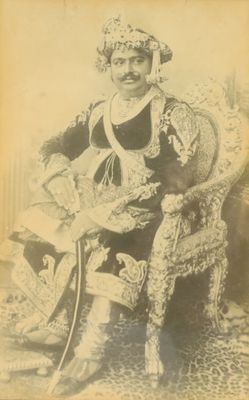 an old photo of a man sitting in a chair with a hat on