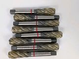 four pieces of drill bits are lined up on a white surface