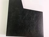 a close up of a piece of black paper on a white surface
