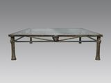 une image représentant une table basse avec un plateau en verre sur fond gris