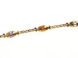 une image représentant un bracelet en or orné de perles multicolores sur fond blanc