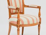 une image représentant une chaise en bois dont l'assise est recouverte d'un tissu rayé