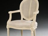 a white chair with a cane back and a beige seat
