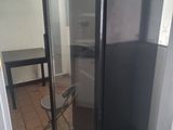 a black refrigerator with a glass door in a kitchen